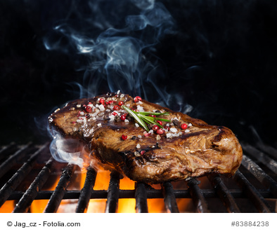 Beef steak on grill, isolated on black background